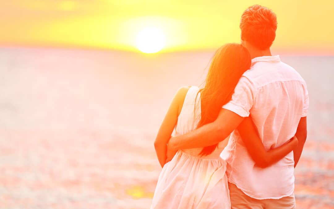 Honeymoon couple romantic in love at beach sunset. Newlywed happ